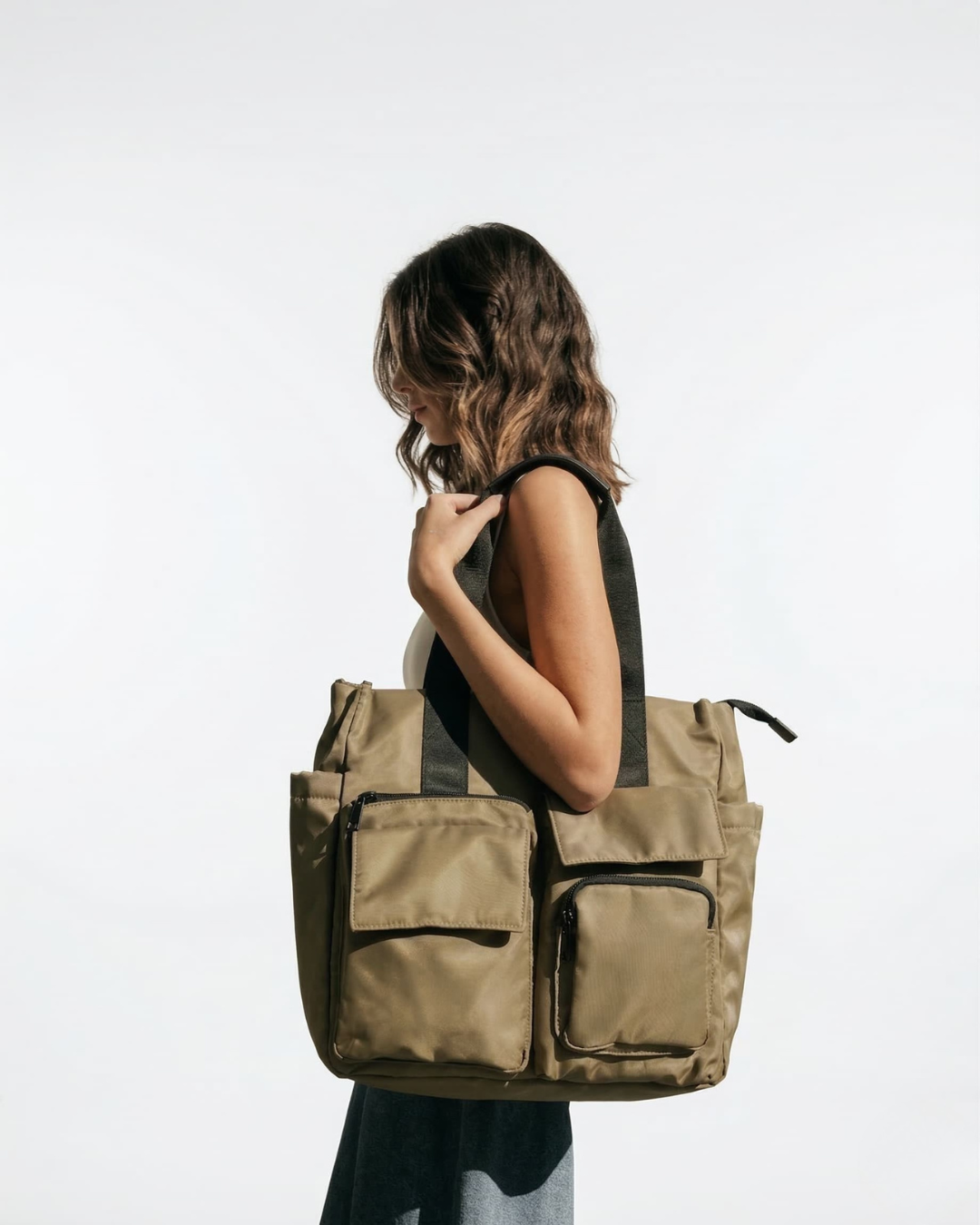 Woman carrying a large green backpack on a white background