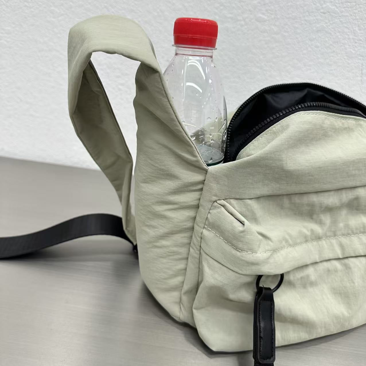 Light-colored backpack with a water bottle inside on a light gray background