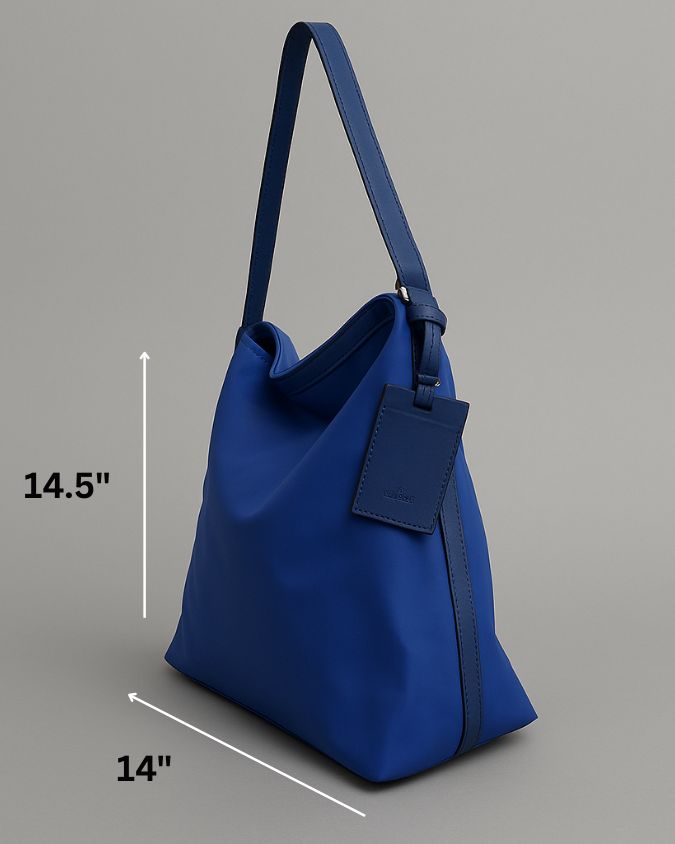 "Minimalist shoulder bag with a structured silhouette, single top strap, and attached tag detail – designed for effortless everyday style. Compact yet spacious enough for daily essentials, perfect for work, brunch, or casual wear. A premium fashion accessory from Tales of Totes, ideal for Indian shoppers seeking elegant, functional handbags beyond standard tote designs."
