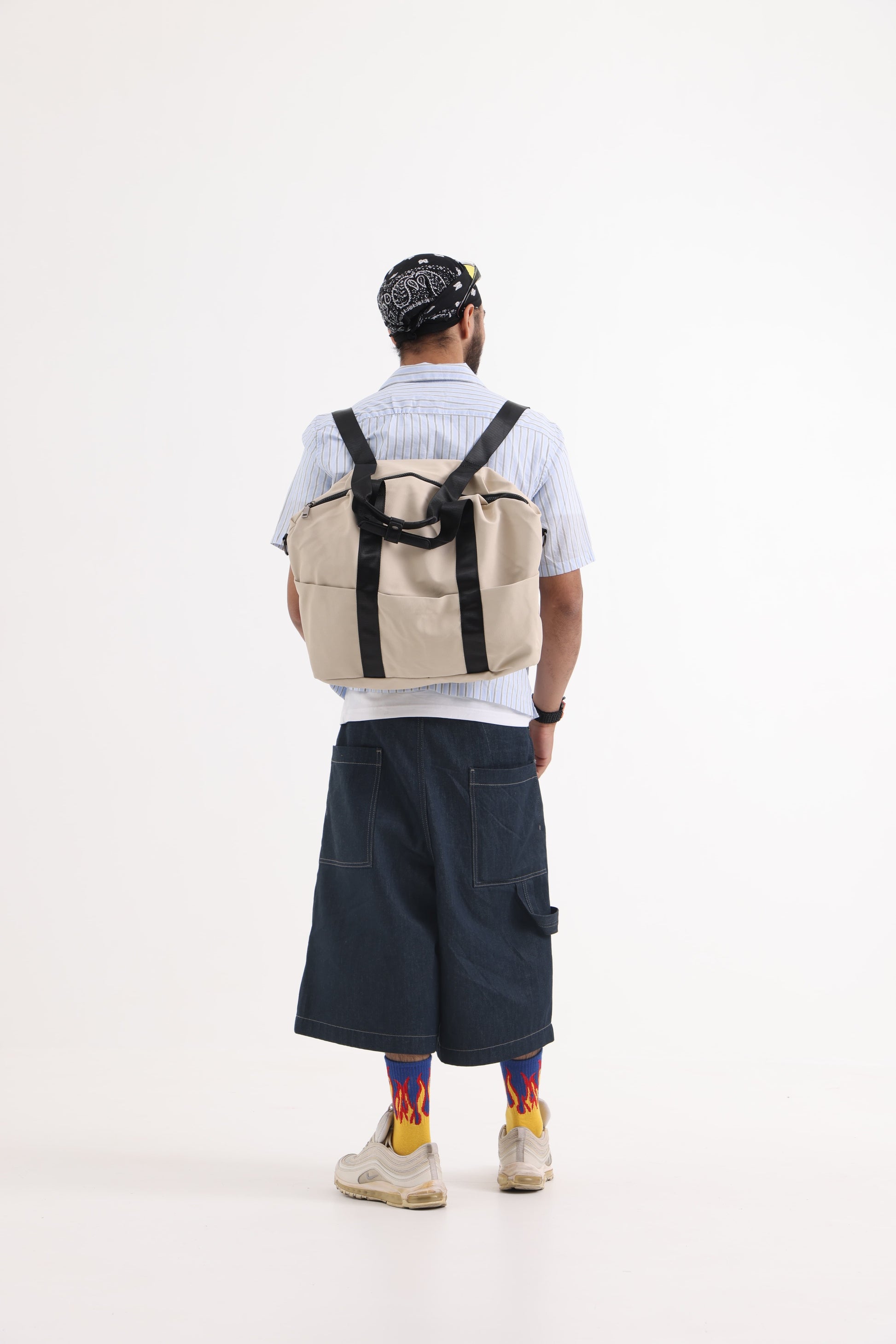A unisex duffel tote bag with a sleek, minimal design featuring two vertical straps, dual carry handles, an adjustable shoulder strap, and side pockets. Spacious enough for travel or daily use, crafted from durable, water-resistant material with a zippered top closure. Ideal for college, gym, or casual outings.
