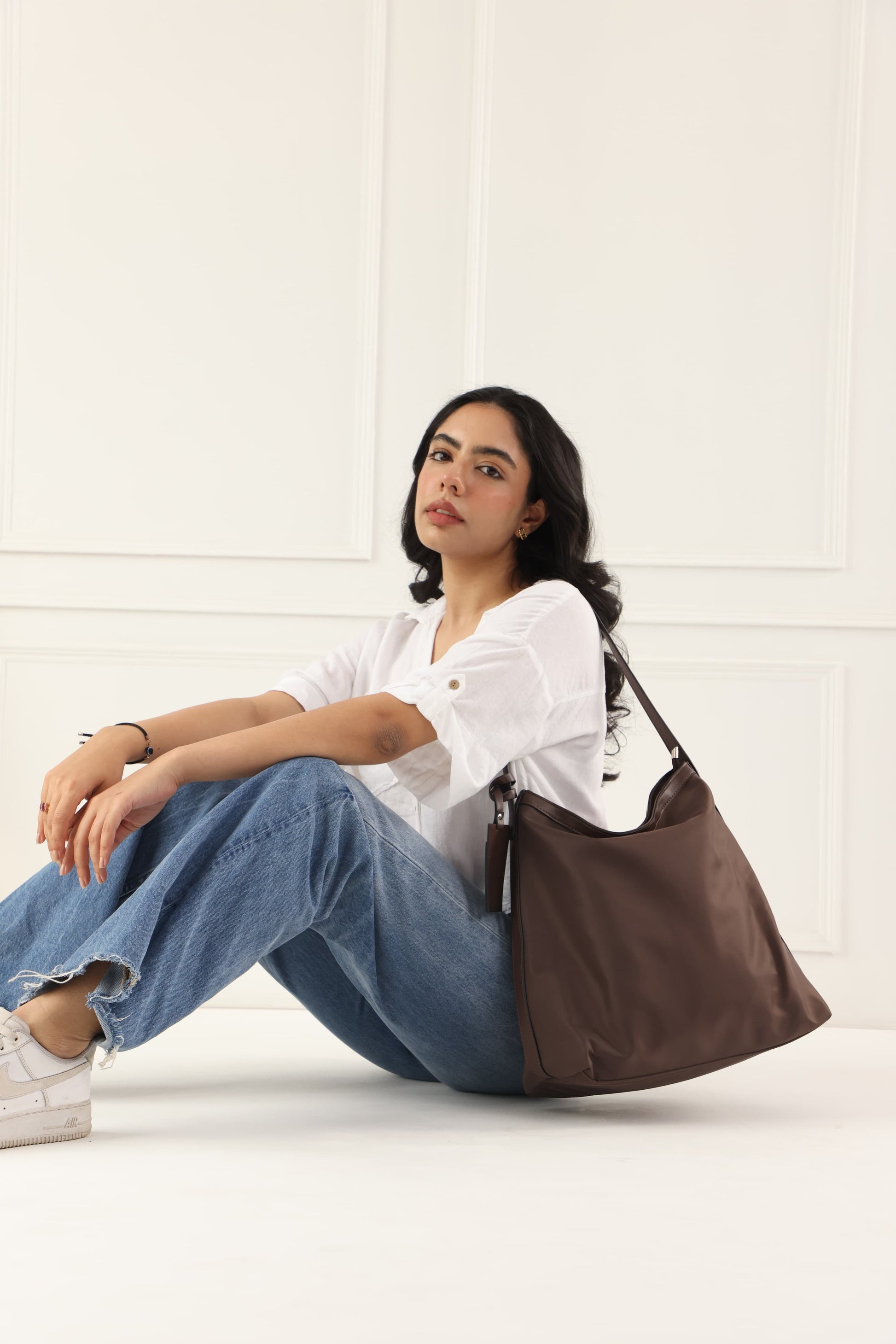"Minimalist shoulder bag with a structured silhouette, single top strap, and attached tag detail – designed for effortless everyday style. Compact yet spacious enough for daily essentials, perfect for work, brunch, or casual wear. A premium fashion accessory from Tales of Totes, ideal for Indian shoppers seeking elegant, functional handbags beyond standard tote designs."
