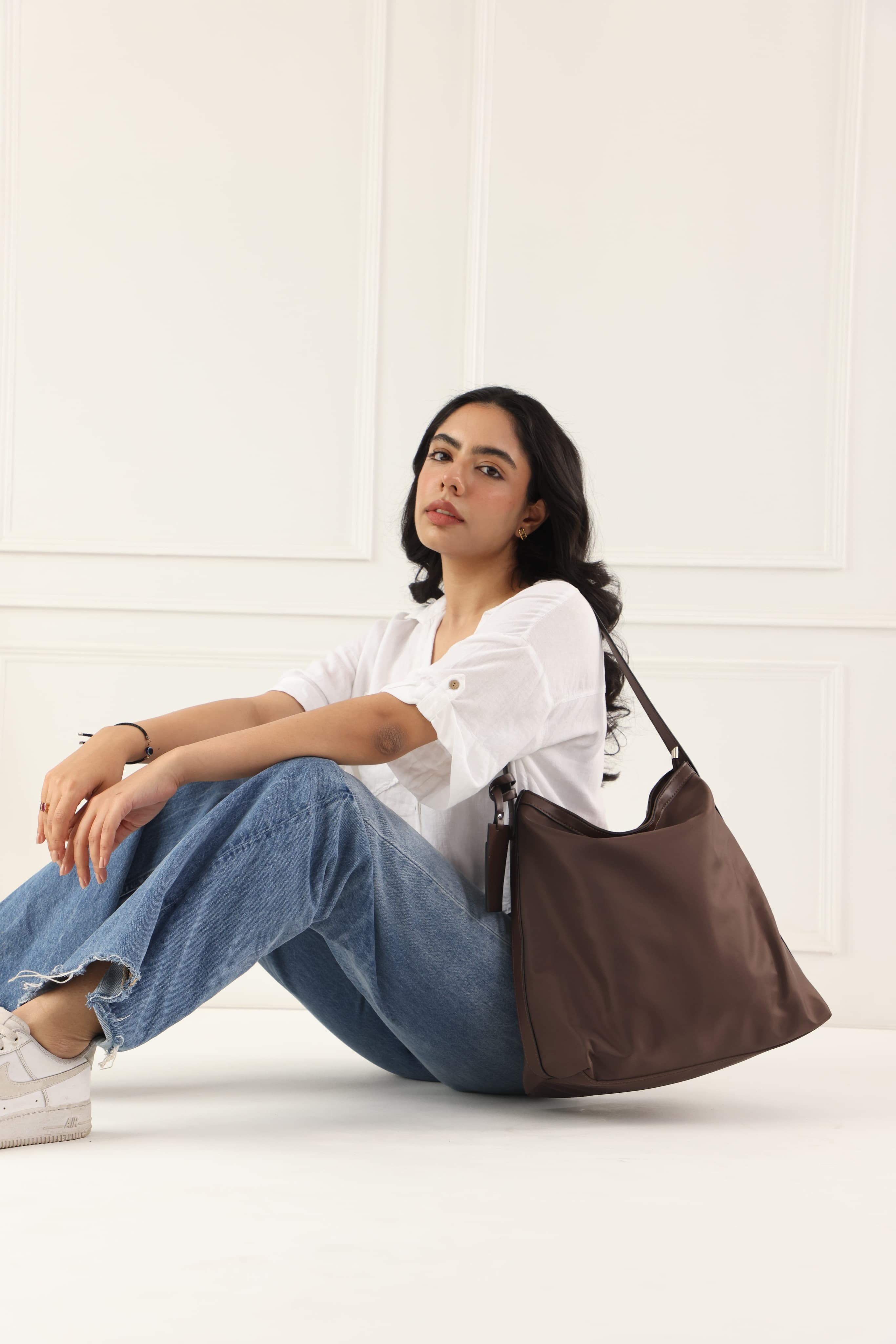 "Minimalist shoulder bag with a structured silhouette, single top strap, and attached tag detail – designed for effortless everyday style. Compact yet spacious enough for daily essentials, perfect for work, brunch, or casual wear. A premium fashion accessory from Tales of Totes, ideal for Indian shoppers seeking elegant, functional handbags beyond standard tote designs."

