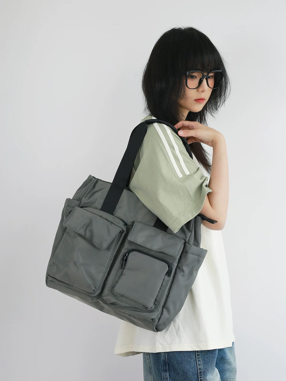 Person holding a large gray bag with a white background
