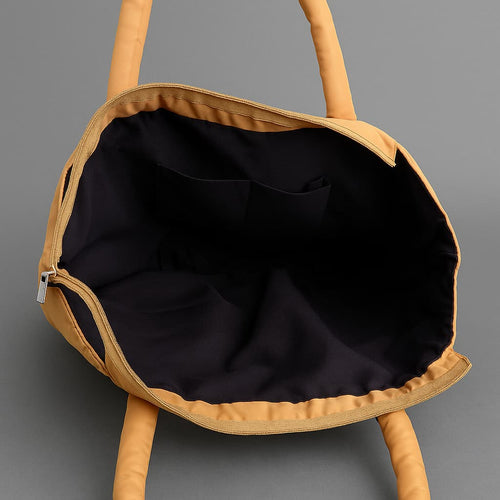 Lightweight nylon tote bag with a padded handle design and front flap pocket – perfect for everyday errands, gym, shopping, or casual travel. Spacious, foldable, and easy to carry with a functional structure that balances fashion and utility. A bold statement piece from Tales of Totes, designed for modern Indian lifestyles and a stylish alternative to basic canvas totes."


