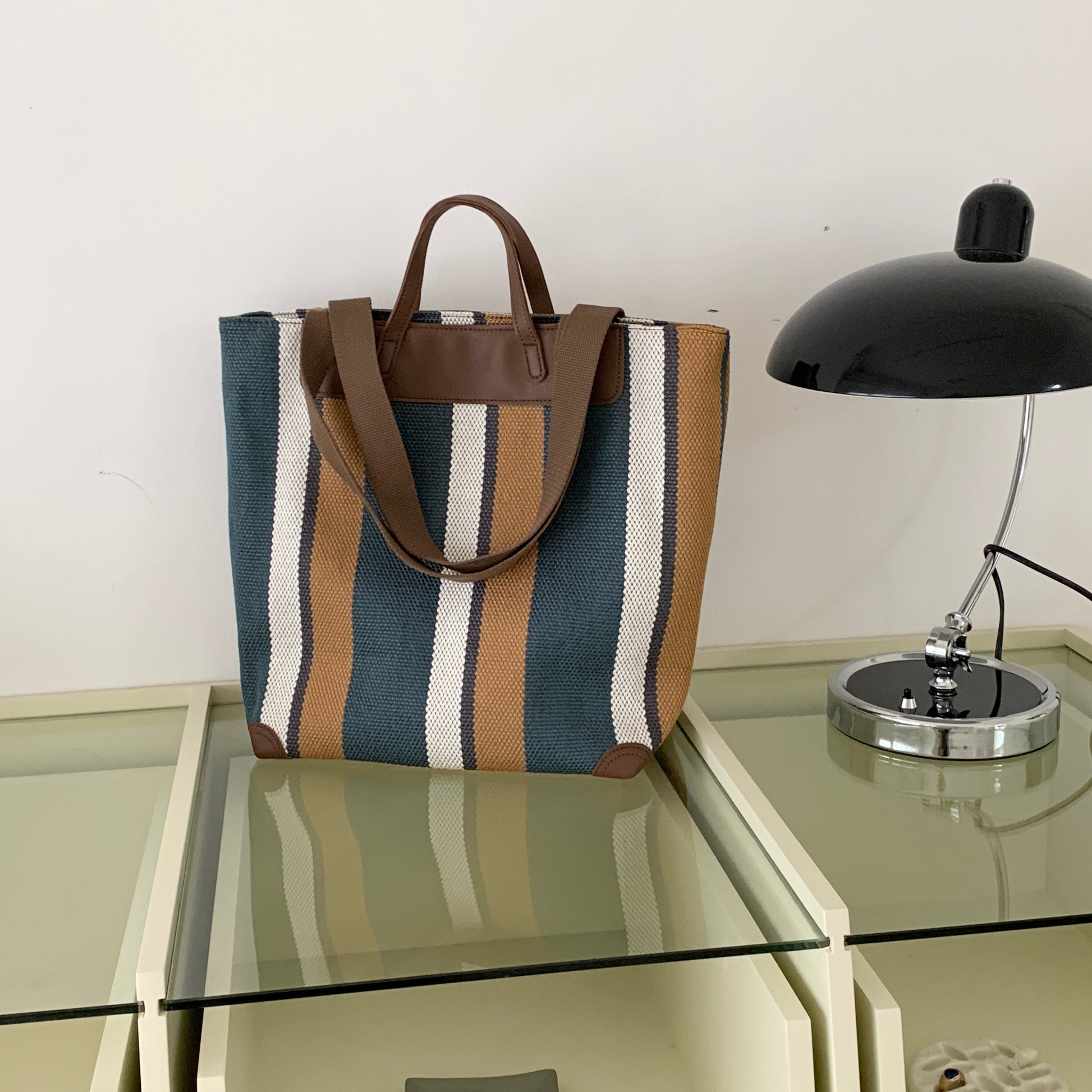 "Eco-friendly striped jute tote bag with dual handles – featuring bold black, grey, and white vertical patterns with leather-look accents and brown straps. Ideal for shopping, office, and casual outings. A sustainable and stylish choice from Tales of Totes – offering earthy, durable fashion accessories that stand apart from brands like Chumbak, Baggit, and DailyObjects in the Indian market."

