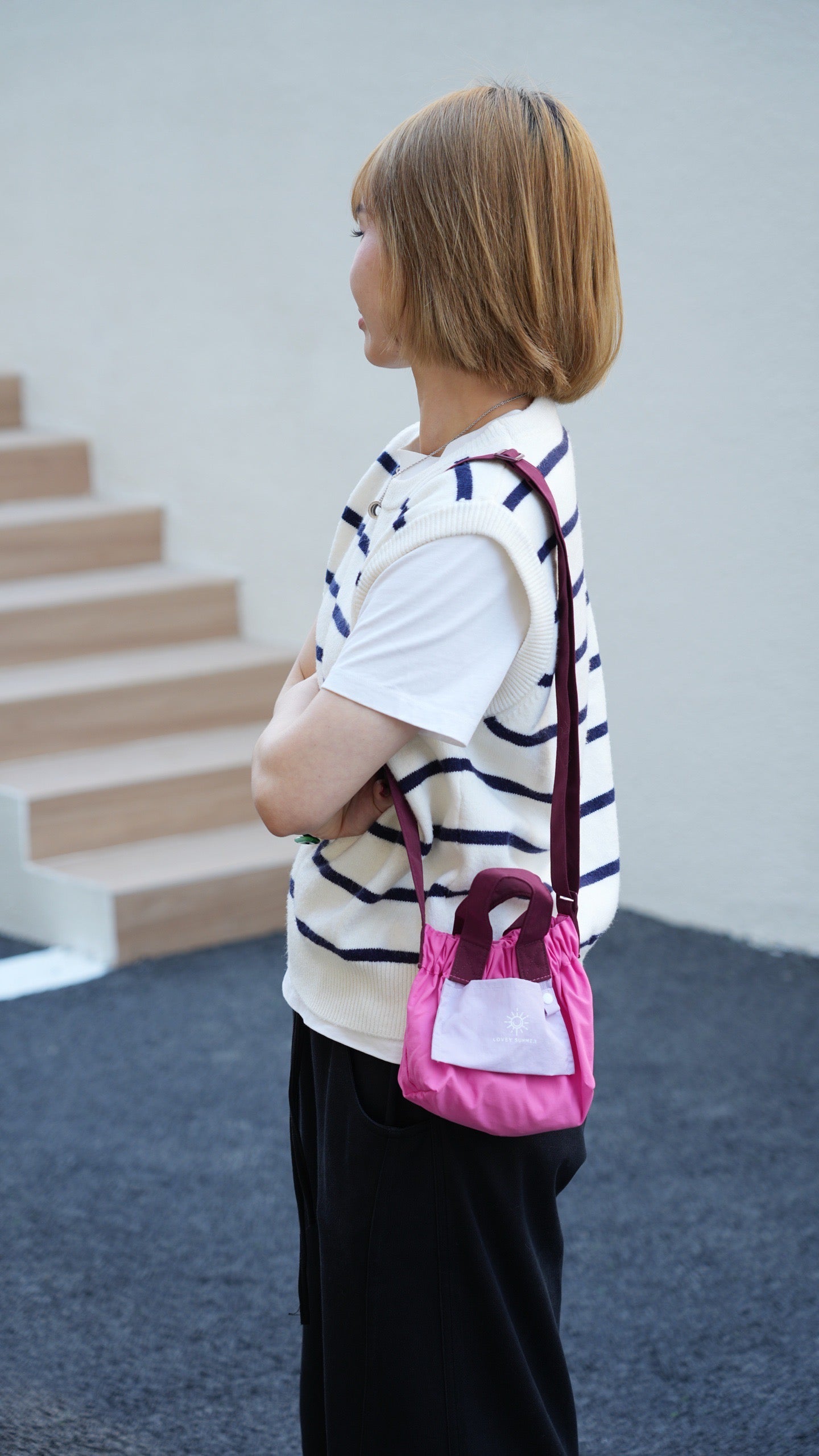 Person holding a pink handbag with a white background