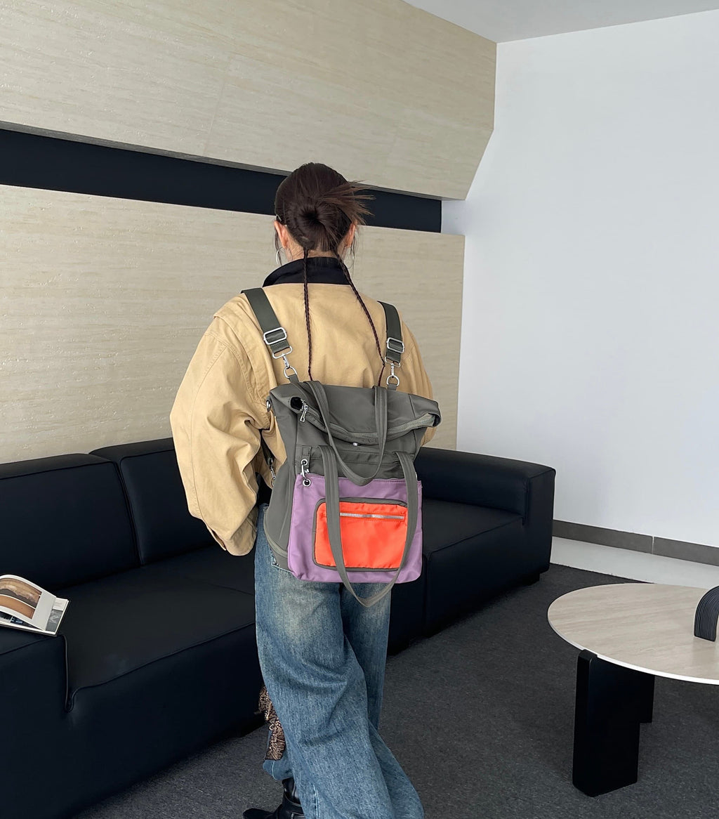 Person wearing a backpack with a visible orange item in a modern indoor setting