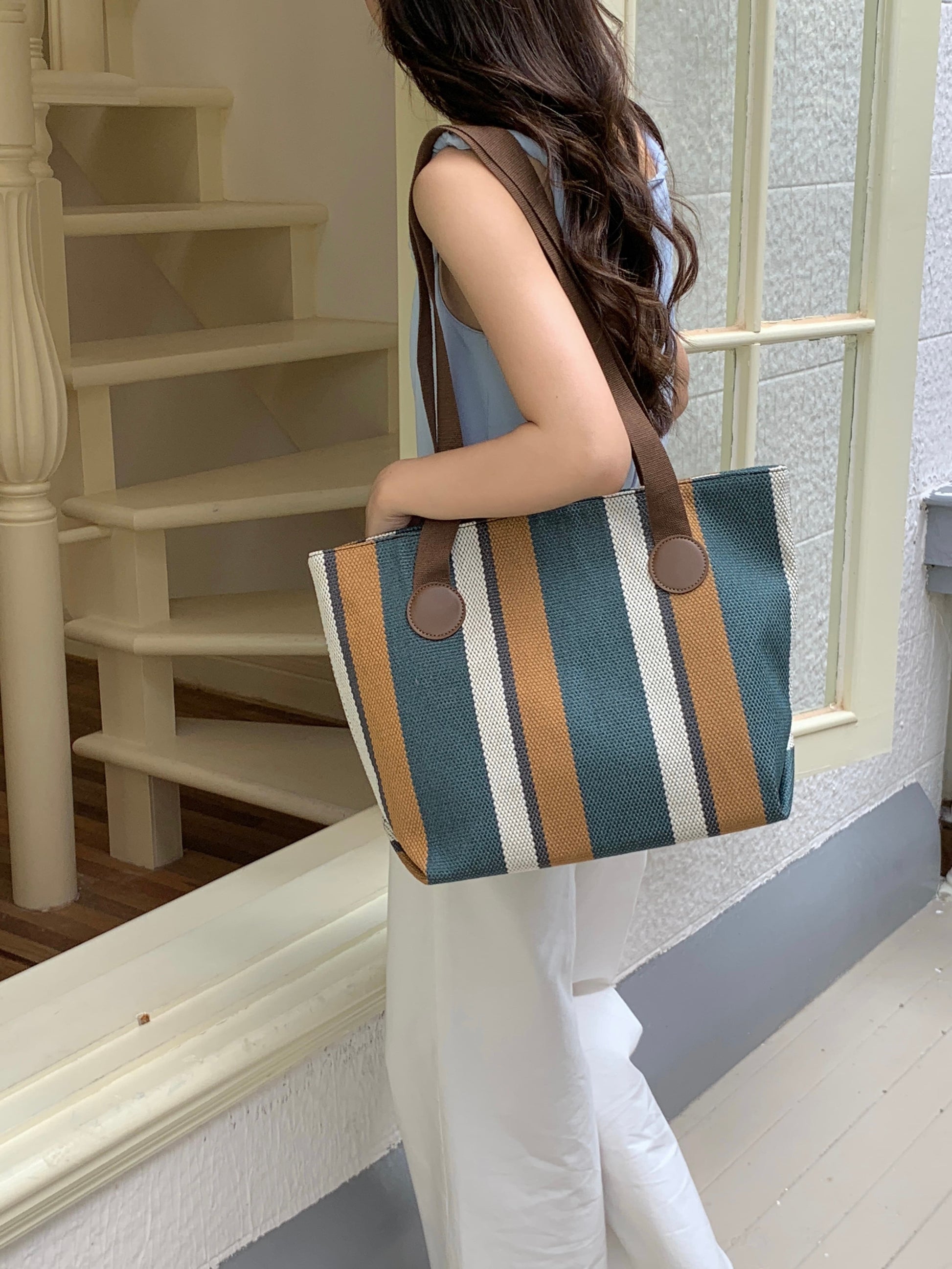 Stylish striped jute tote bag with earthy yellow and beige tones, featuring long brown shoulder straps and circular leather-look accents. Lightweight, eco-conscious, and perfect for daily use, shopping, or office carry. A trendy, sustainable option from Tales of Totes – designed to stand out among Indian tote brands like Chumbak, Baggit, and Zouk."