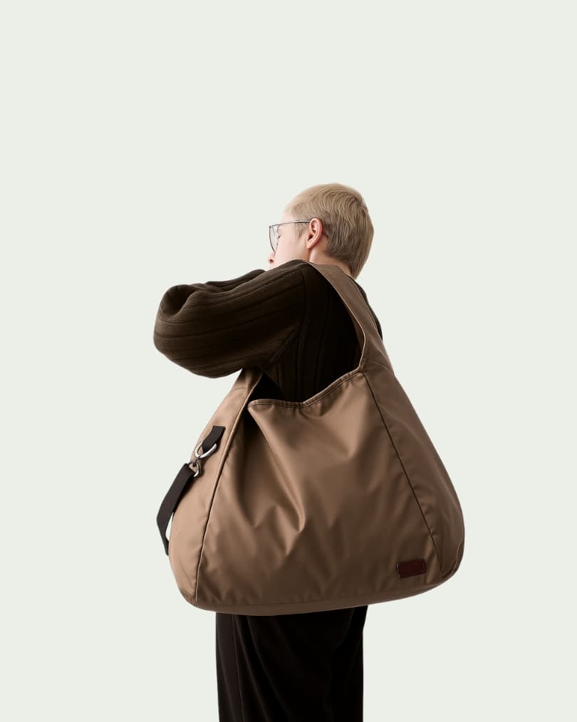 Minimalist black tote bag with a padded top handle, detachable crossbody strap, and front zipper pocket – made from water-resistant fabric for everyday functionality. Lightweight yet spacious, ideal for travel, office, gym, or casual use. A sleek and versatile design by Tales of Totes, offering modern utility and elevated style for Indian shoppers."