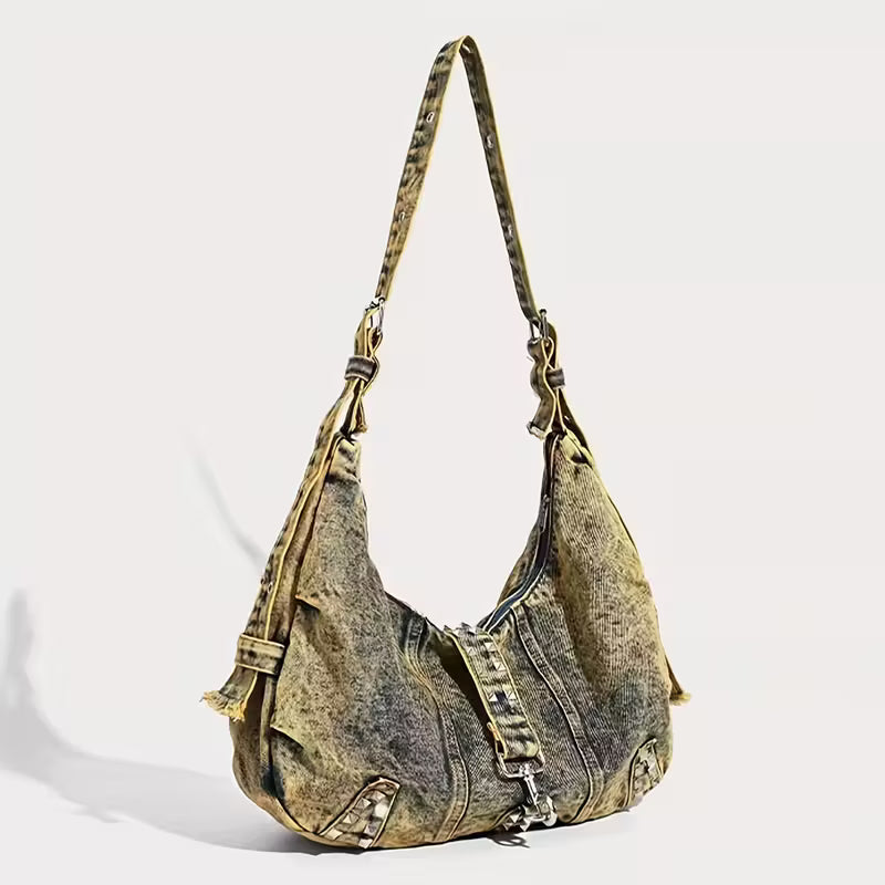 Denim handbag with zippers on a light gray background