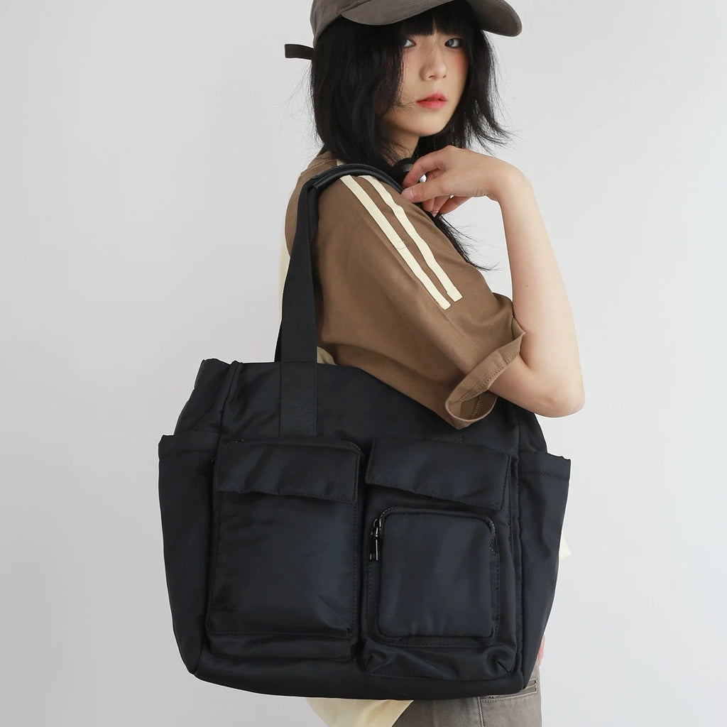 Person holding a black bag with a plain background