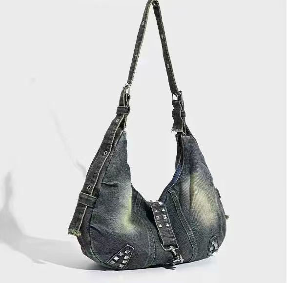 Denim handbag with studs on a light gray background