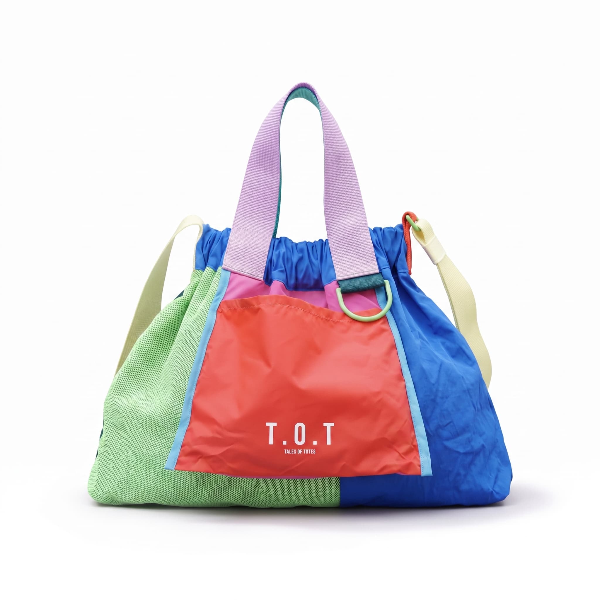 Four colorful T.O.T canvas tote bags in pastel and bright colors hanging from a cream-colored peg rail on a white wall.