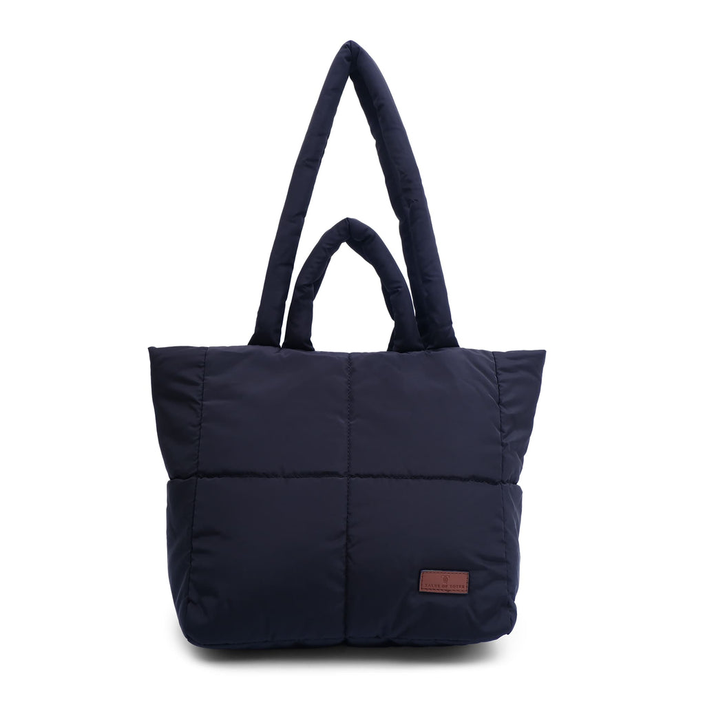 black tote bag with a brown patch on a white background "Minimalist shoulder bag with a structured silhouette, single top strap, and attached tag detail – designed for effortless everyday style. Compact yet spacious enough for daily essentials, perfect for work, brunch, or casual wear. A premium fashion accessory from Tales of Totes, ideal for Indian shoppers seeking elegant, functional handbags beyond standard tote designs."
