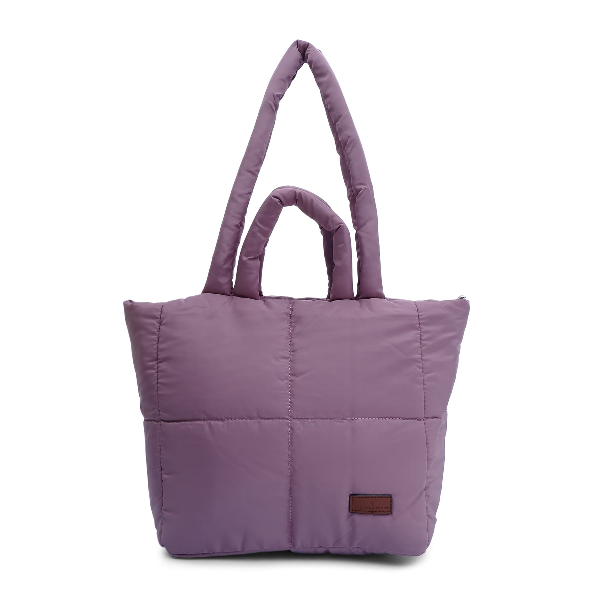 Purple quilted tote bag with a brown label on a white background "Minimalist shoulder bag with a structured silhouette, single top strap, and attached tag detail – designed for effortless everyday style. Compact yet spacious enough for daily essentials, perfect for work, brunch, or casual wear. A premium fashion accessory from Tales of Totes, ideal for Indian shoppers seeking elegant, functional handbags beyond standard tote designs."
