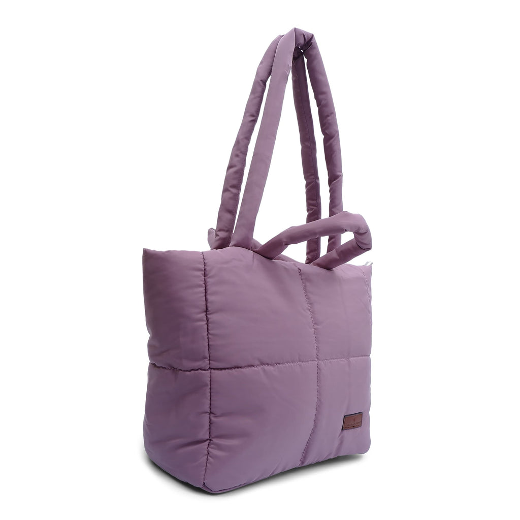 Purple quilted tote bag on a white background"Minimalist shoulder bag with a structured silhouette, single top strap, and attached tag detail – designed for effortless everyday style. Compact yet spacious enough for daily essentials, perfect for work, brunch, or casual wear. A premium fashion accessory from Tales of Totes, ideal for Indian shoppers seeking elegant, functional handbags beyond standard tote designs."

