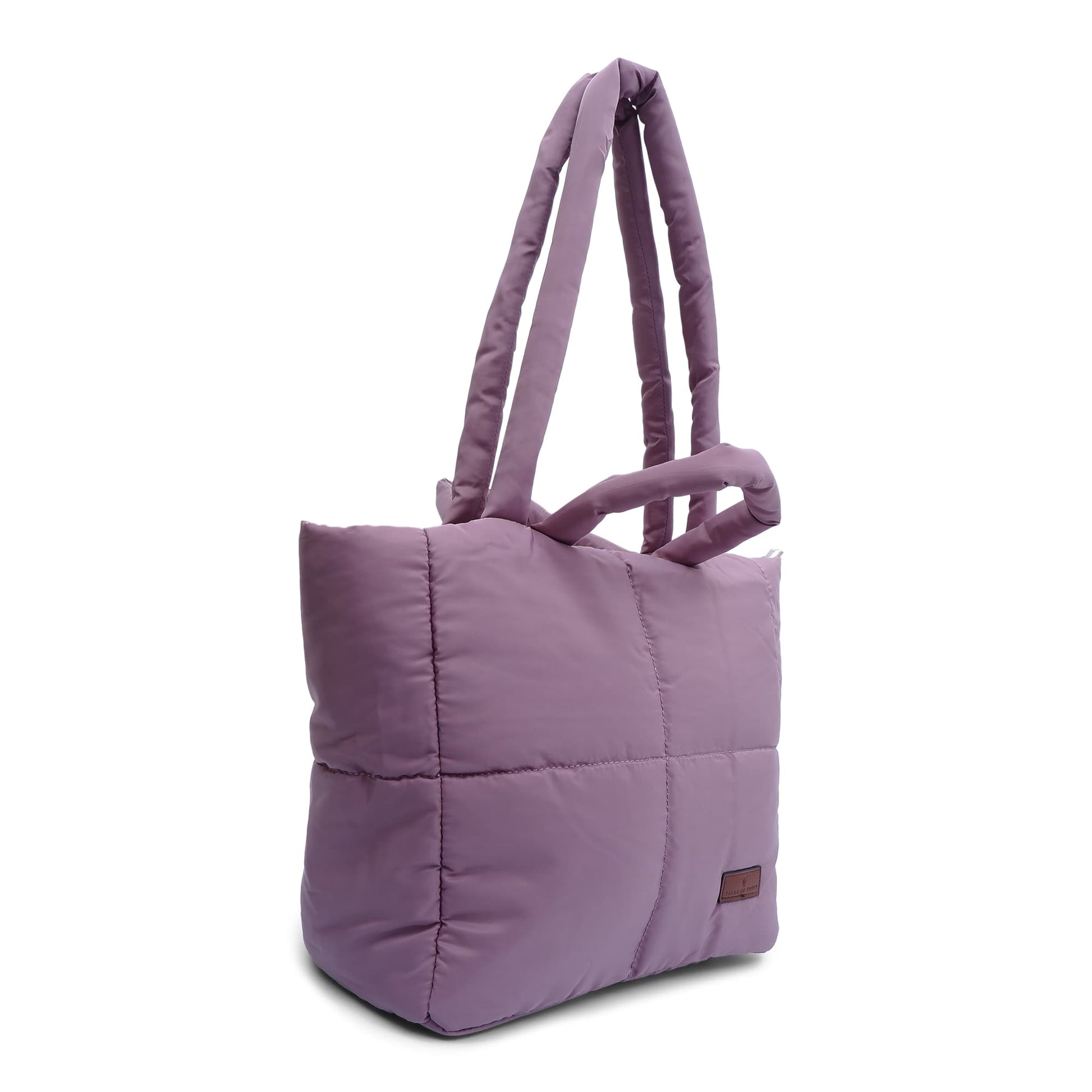 Purple quilted tote bag on a white background"Minimalist shoulder bag with a structured silhouette, single top strap, and attached tag detail – designed for effortless everyday style. Compact yet spacious enough for daily essentials, perfect for work, brunch, or casual wear. A premium fashion accessory from Tales of Totes, ideal for Indian shoppers seeking elegant, functional handbags beyond standard tote designs."
