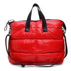 Red puffer bag with black straps on a white background