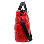 Red puffer bag with a black strap on a white background
