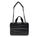 Black leather handbag with a strap on a white background