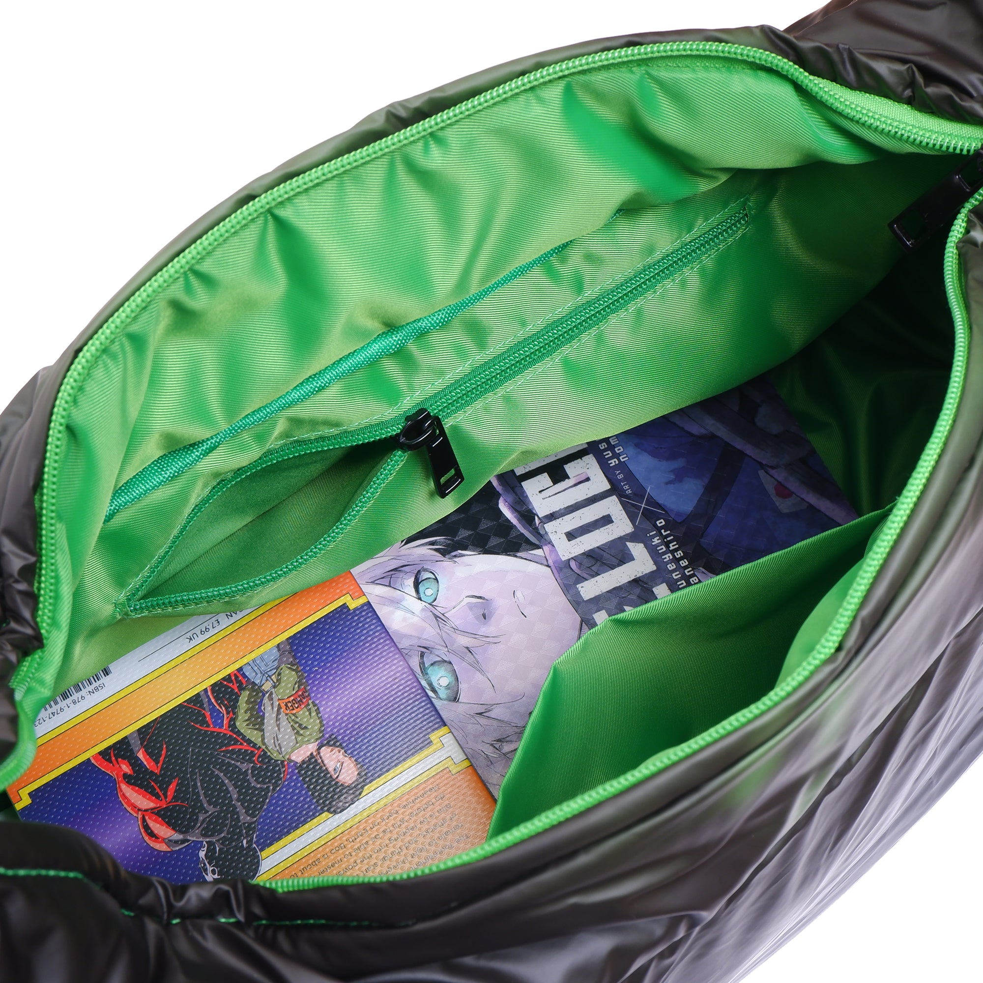 Open bag with green interior showing comic books and a card game.