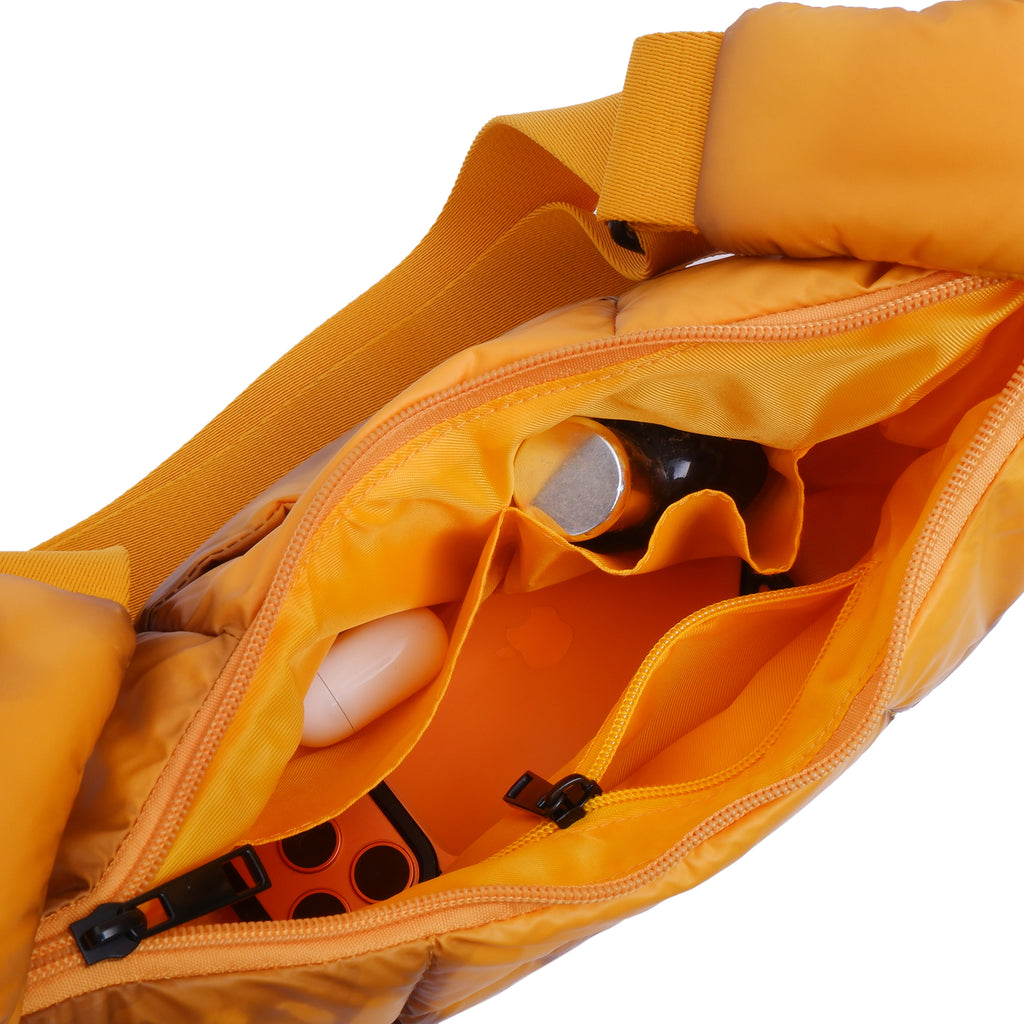 Close-up of an open orange bag revealing a white object and black tool inside.