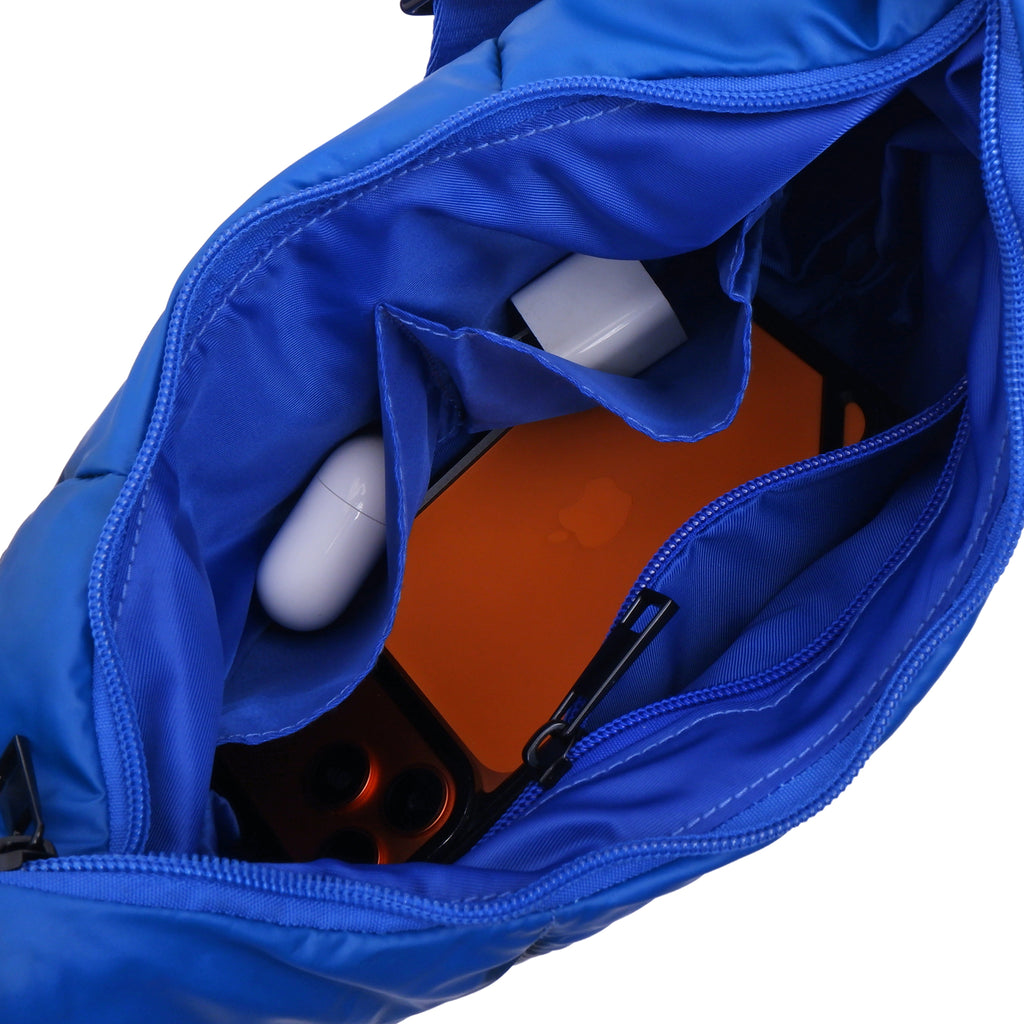 Blue bag with sunglasses and a white bottle inside on a white background