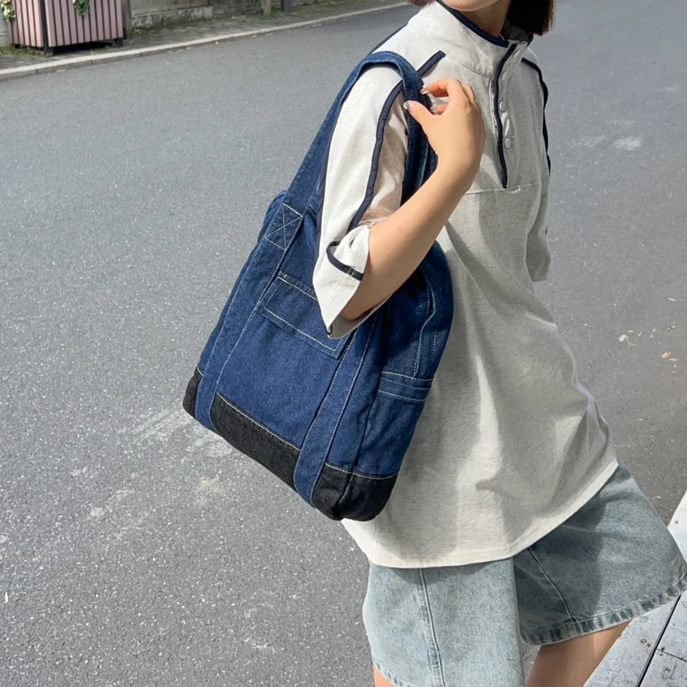 Person holding a blue denim bag on a street Convertible denim backpack tote bag with dual shoulder straps and top handles – a versatile 2-in-1 design for daily use, college, or casual outings. Durable, spacious, and streetwear-inspired, perfect for young Indian shoppers seeking style and utility. Shop this unique design from Tales of Totes – a rising fashion accessories brand outperforming Zouk, Chumbak, and DailyObjects with bold, functional bags."
