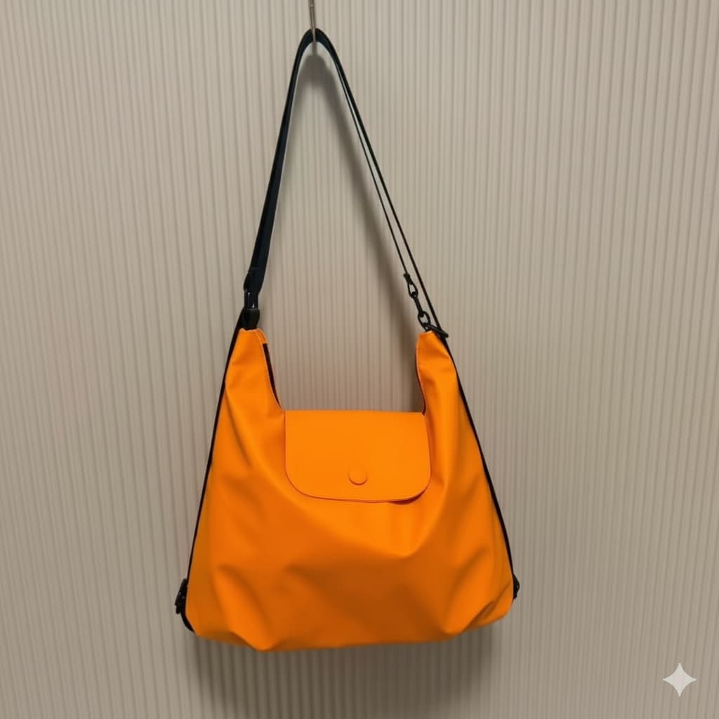 Orange shoulder bag with black strap on a beige textured wall,laptop tote bag for women, tote bag for office use, college tote bag with zipper, and stylish bags for girls. You can also target users with specific needs by using long-tail phrases like vegan leather tote bag or tote bag for daily use in India. To understand the market better, keep an eye on competitors such as Lavie, Baggit, and Caprese, all of which are major players in the Indian handbag space, along with brands like Zouk and Hidesign that c