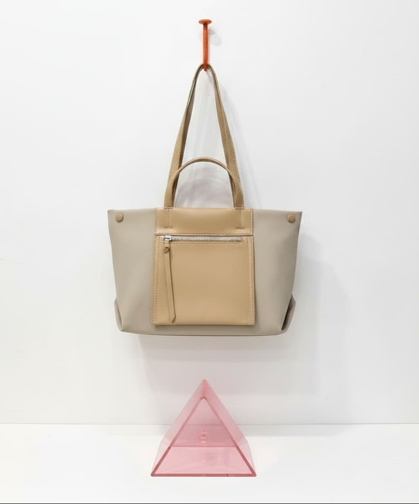 Beige tote bag with beige pocket on a white background,Elegant black tote bag with a sleek leather-look finish, front zip pocket, and spacious interior – perfect for office, travel, or daily use. Features dual handles, multiple compartments, and secure zip closure. A premium alternative to Zouk, DailyObjects, and Lavie bags. Shop functional yet stylish fashion accessories at Tales of Totes – India’s go-to brand for modern totes."