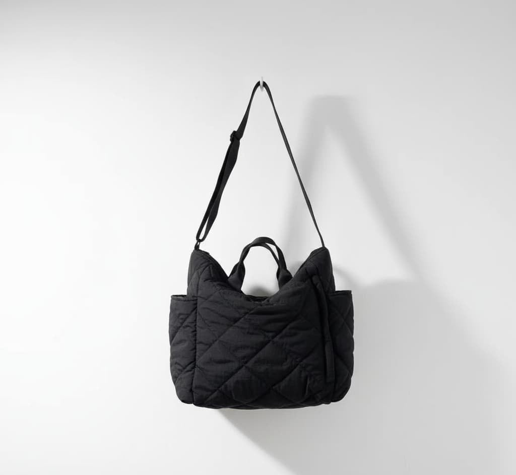 Black quilted handbag on a light gray background