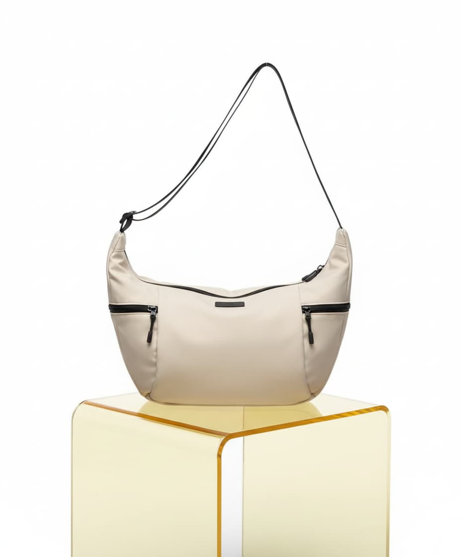 Beige handbag with black accents on a transparent yellow stand against a white background