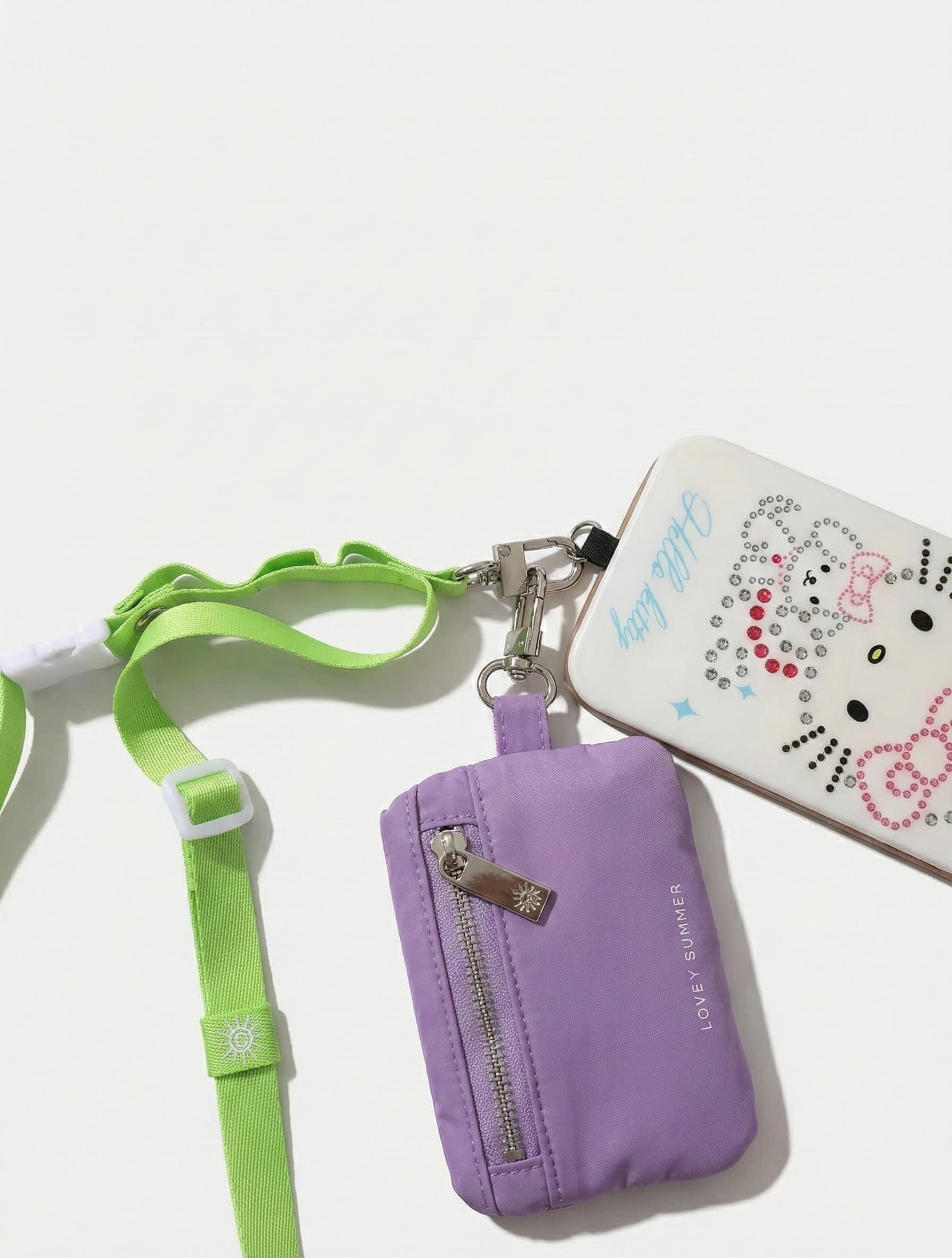 Purple pouch with green strap and Hello Kitty phone case on a white background