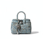 Denim handbag with decorative elements on a white background