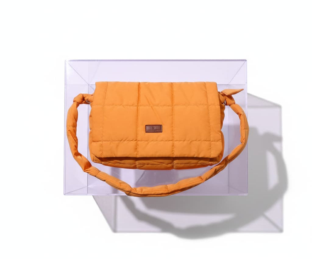 Orange quilted handbag on a white background, 