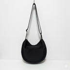 Black shoulder bag with a strap on a white background,Trendy emerald green crescent half-moon shoulder bag for women, durable canvas, versatile for daily use, ethnic wear, and casual outings in India. This stylish sling bag offers a modern minimalist design, spacious interior, functioning as a chic carryall or small hobo tote.