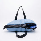 Light blue bag with black zipper and straps on a white background