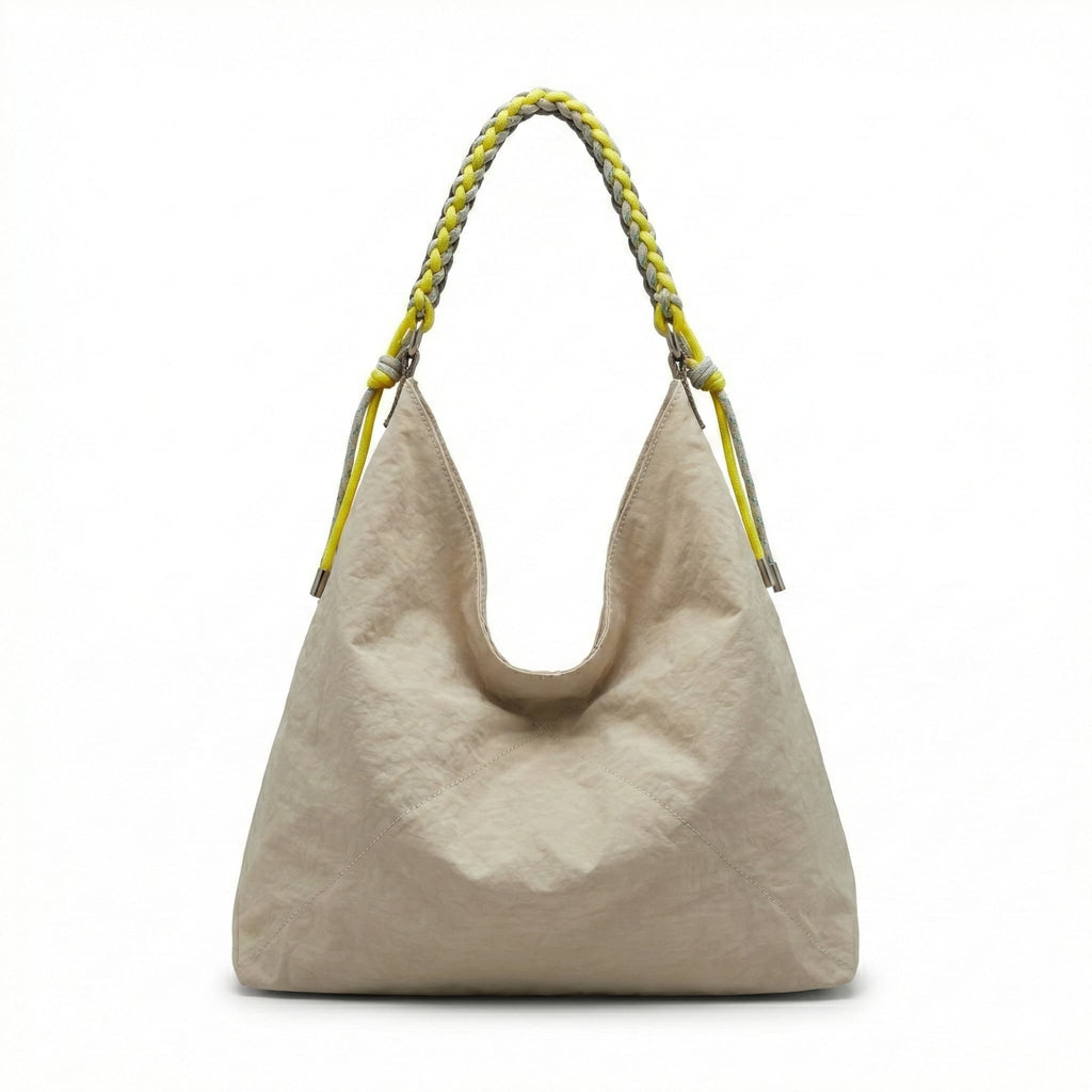 Beige handbag with a braided handle on a white background