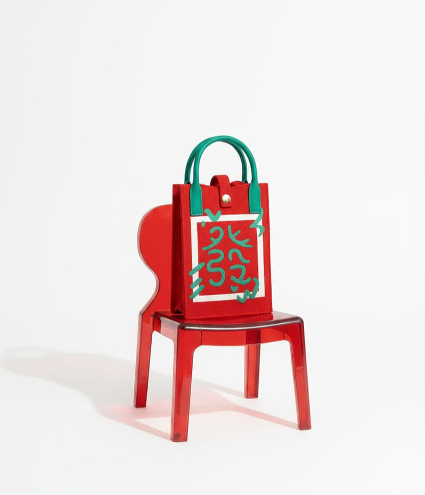 Red chair with a green handbag on a white background