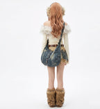 Person wearing a denim outfit with fur accents on a white background