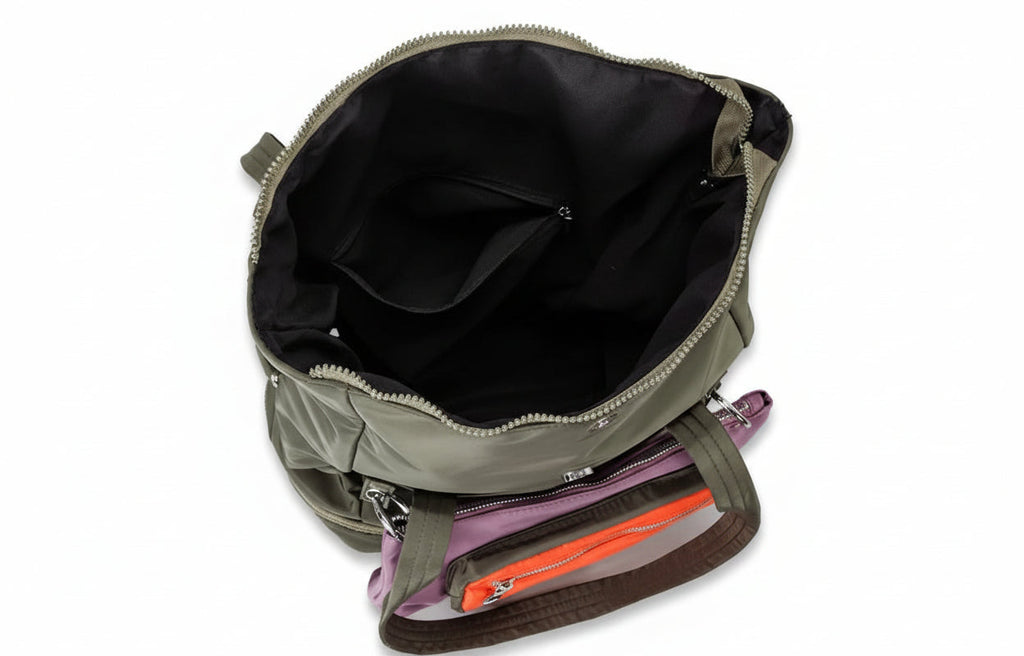 Open green backpack with colorful items inside on a white background