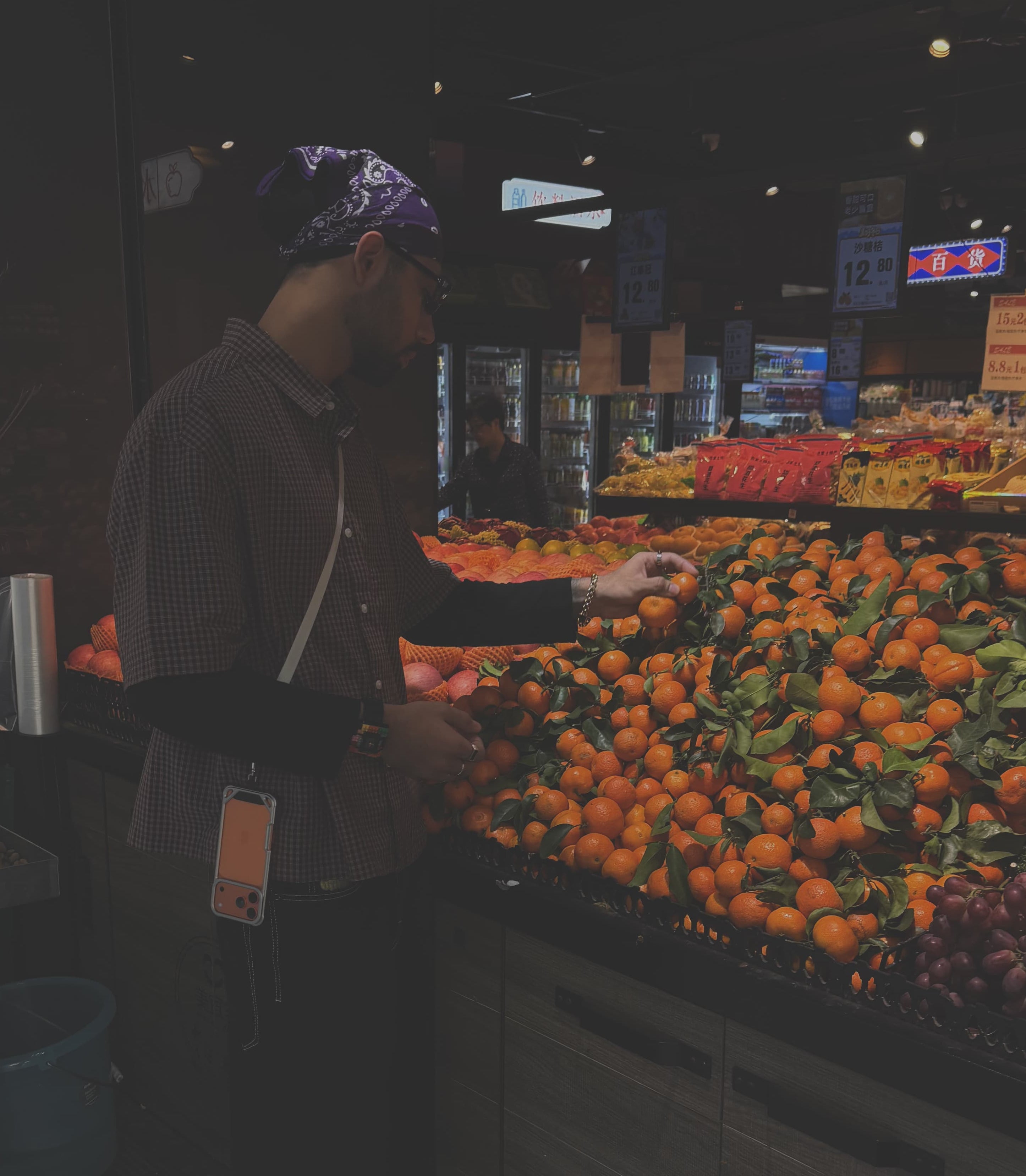 Person shopping in a grocery store with produce in the foreground