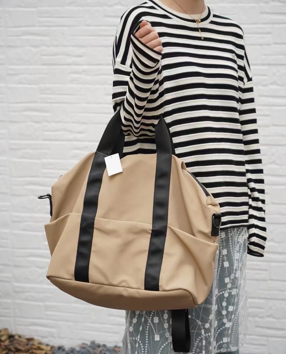 A unisex duffel tote bag with a sleek, minimal design featuring two vertical straps, dual carry handles, an adjustable shoulder strap, and side pockets. Spacious enough for travel or daily use, crafted from durable, water-resistant material with a zippered top closure. Ideal for college, gym, or casual outings.





A unisex duffel tote bag with a sleek, minimal design featuring two vertical straps, dual carry handles, an adjustable shoulder strap, and side pockets. Spacious enough for travel or daily us


