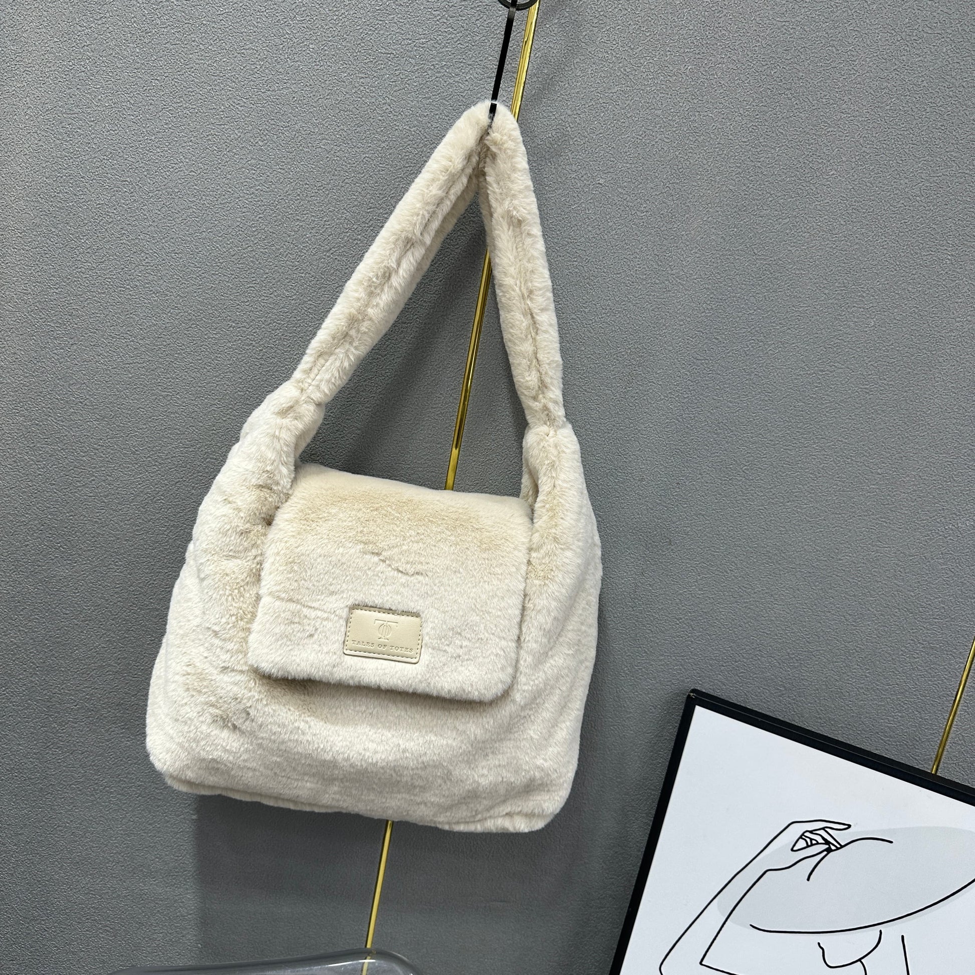 Soft faux fur tote bag with padded handles, front flap pocket, and zippered main compartment – designed for cozy winter style and functional everyday use. Spacious enough for essentials like cosmetics, wallet, and phone. A trendy winter accessory from Tales of Totes, offering stylish comfort beyond Indian brands like Zouk, Chumbak, and Miraggio."

