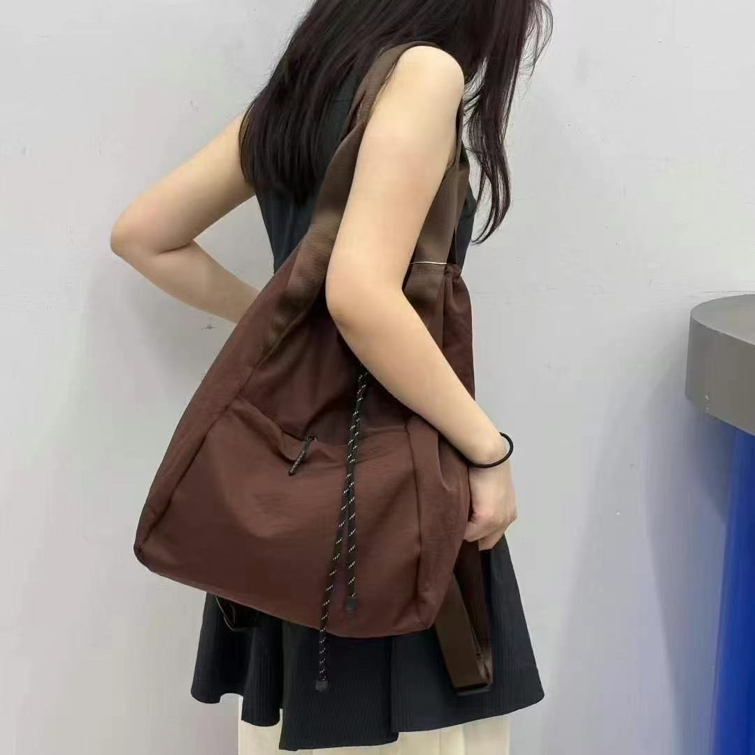 Person wearing a brown backpack against a plain background,"Stylish khaki drawstring tote bag with multiple compartments and adjustable straps, perfect for daily use, shopping, and travel in India. Features include a secure zippered pocket, spacious main compartment, and comfortable shoulder straps. Ideal for fashion-conscious individuals seeking a versatile and trendy bag."