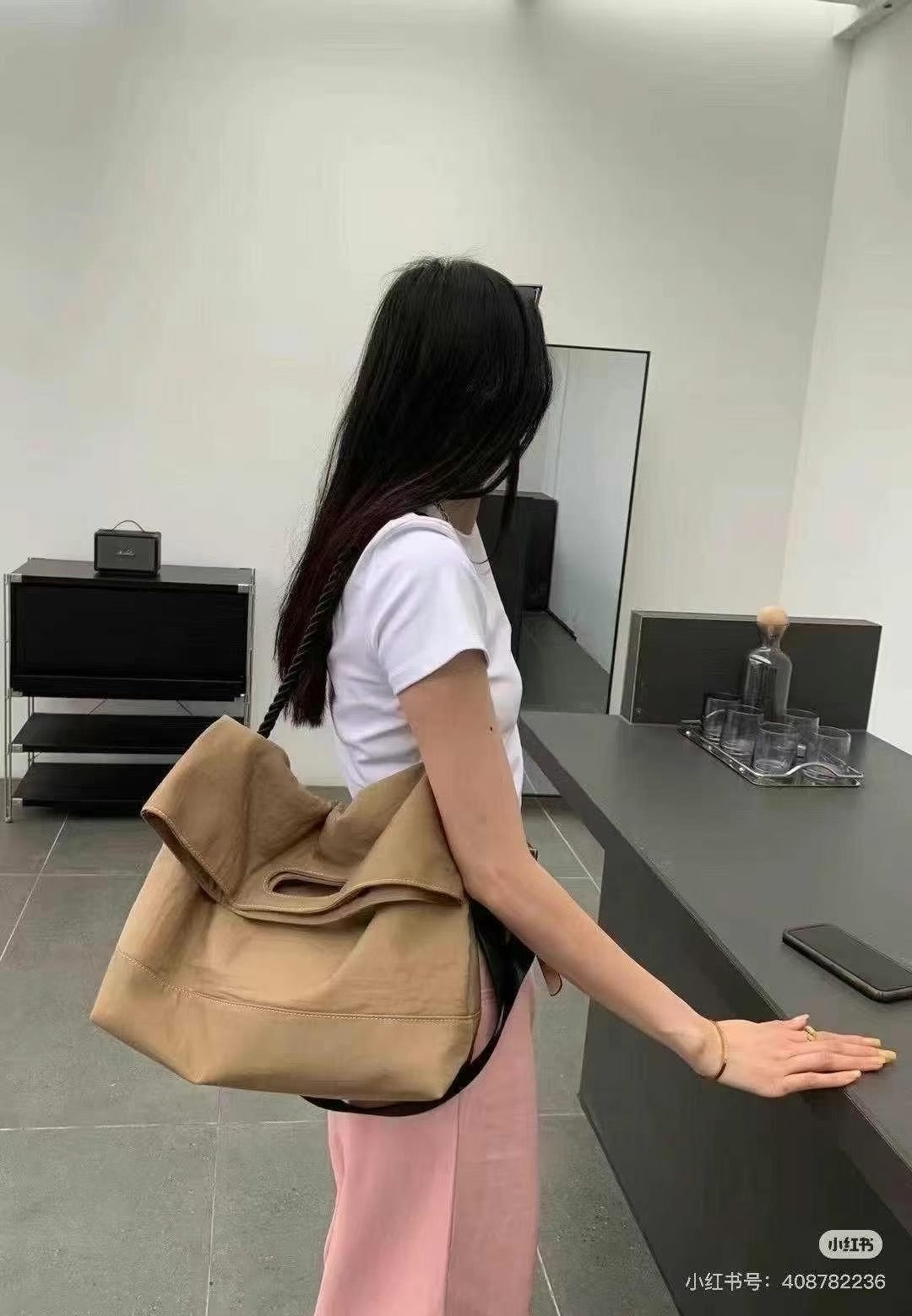 Person holding a beige bag in an office setting,Black handbag with a rope handle held by a person on a white surface.,High-quality red tote bag for women and girls from a new Indian fashion brand. Features a unique top-fold flap design and sturdy braided black rope handles. Perfect for carrying laptops and essentials, making it a stylish and functional bag for office, college, or casual outings in India. A chic and trending design for the modern Indian woman, available online with free shipping.