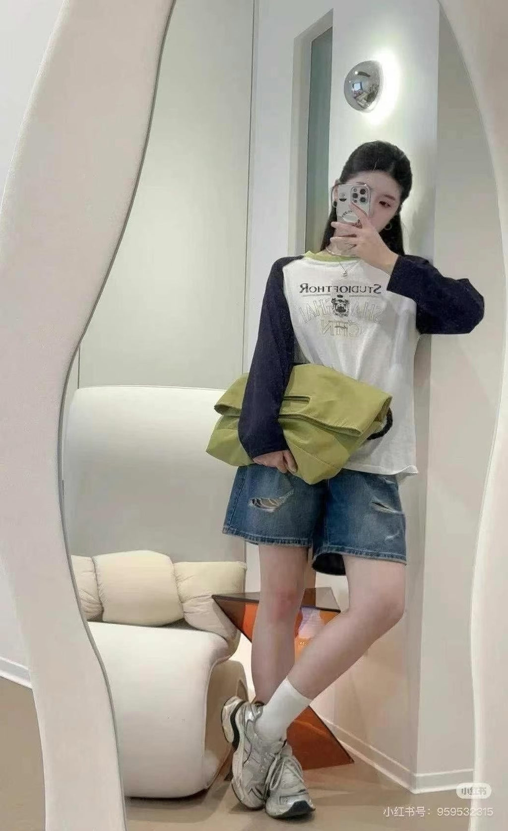 Person taking a mirror selfie wearing a white shirt with text, green bag, and denim shorts.Black handbag with a rope handle held by a person on a white surface.,High-quality red tote bag for women and girls from a new Indian fashion brand. Features a unique top-fold flap design and sturdy braided black rope handles. Perfect for carrying laptops and essentials, making it a stylish and functional bag for office, college, or casual outings in India. A chic and trending design for the modern Indian woman, avail