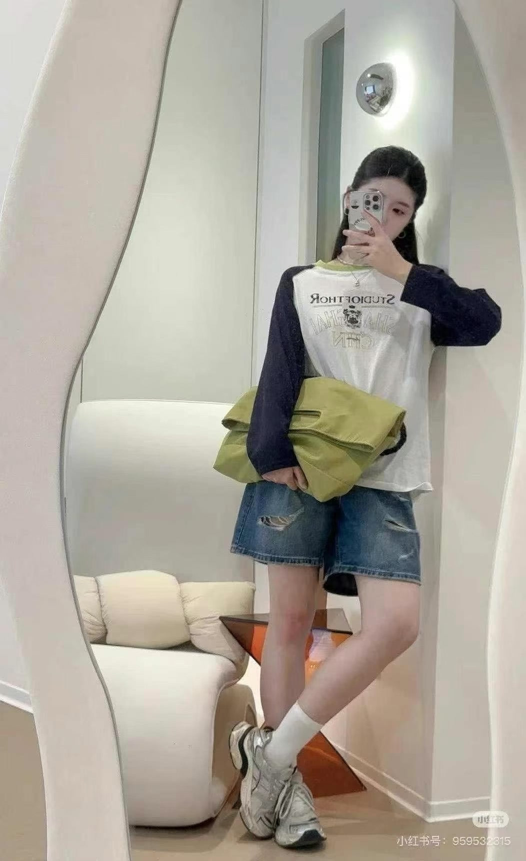 Person taking a mirror selfie wearing a white shirt with text, green bag, and denim shorts.Black handbag with a rope handle held by a person on a white surface.,High-quality red tote bag for women and girls from a new Indian fashion brand. Features a unique top-fold flap design and sturdy braided black rope handles. Perfect for carrying laptops and essentials, making it a stylish and functional bag for office, college, or casual outings in India. A chic and trending design for the modern Indian woman, avail