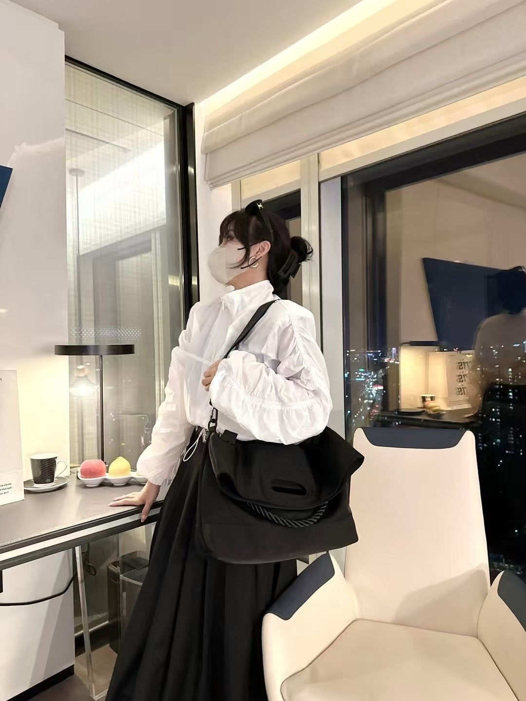 Person wearing a white blouse and black skirt in a modern room with a cityscape view.Black handbag with a rope handle held by a person on a white surface.,High-quality red tote bag for women and girls from a new Indian fashion brand. Features a unique top-fold flap design and sturdy braided black rope handles. Perfect for carrying laptops and essentials, making it a stylish and functional bag for office, college, or casual outings in India. A chic and trending design for the modern Indian woman, available o