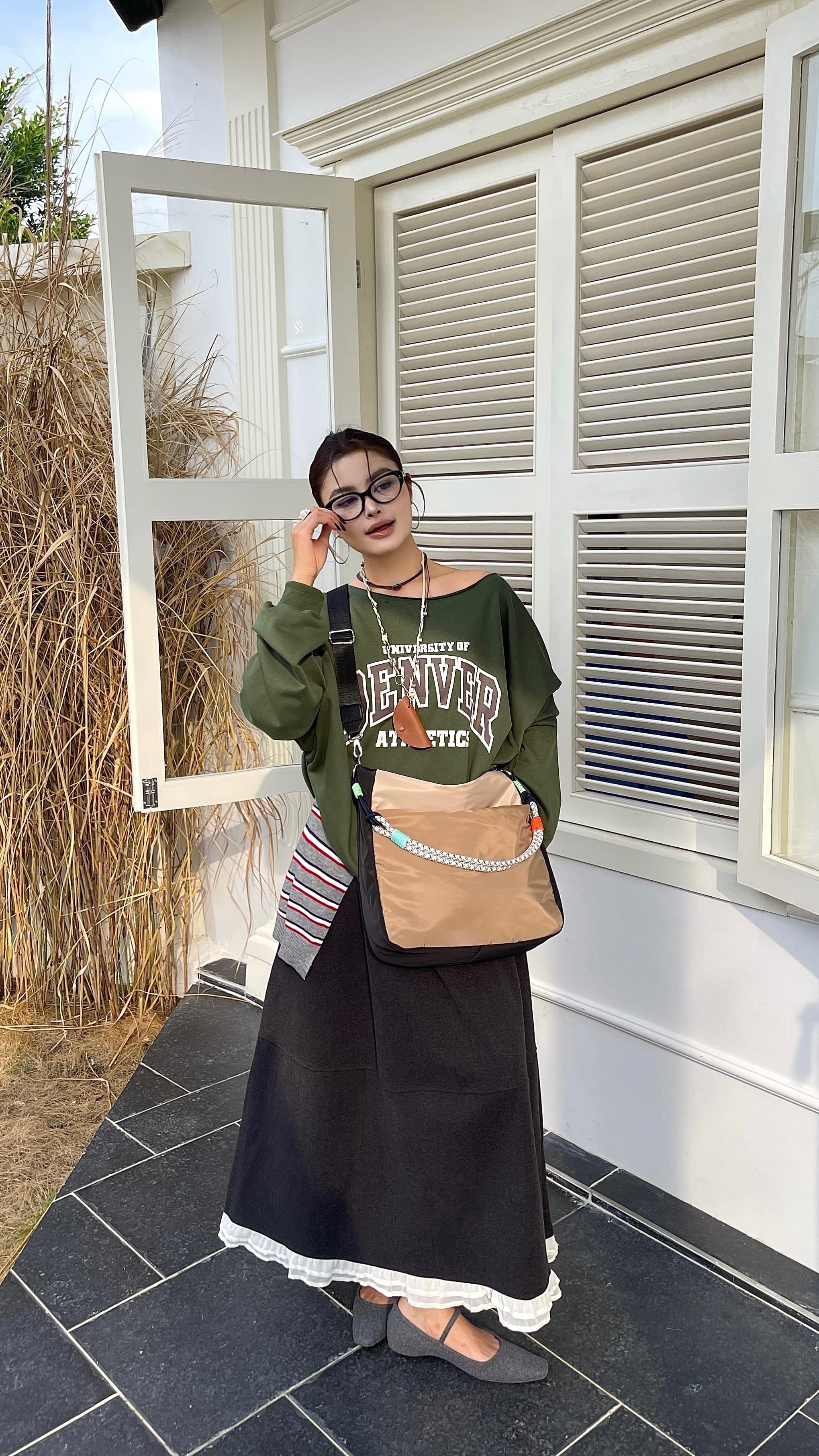 Woman holding a large open window frame in front of a house. Multi-pocket travel tote bag with 20-litre capacity and compact dimensions (35 x 35 x 10 cm), featuring a wide adjustable strap and color-blocked utility design. Lightweight, durable, and ideal for travel, college, or daily use. A high-performance everyday essential from Tales of Totes – built for comfort, style, and smart organization in India’s fast-paced lifestyle."
